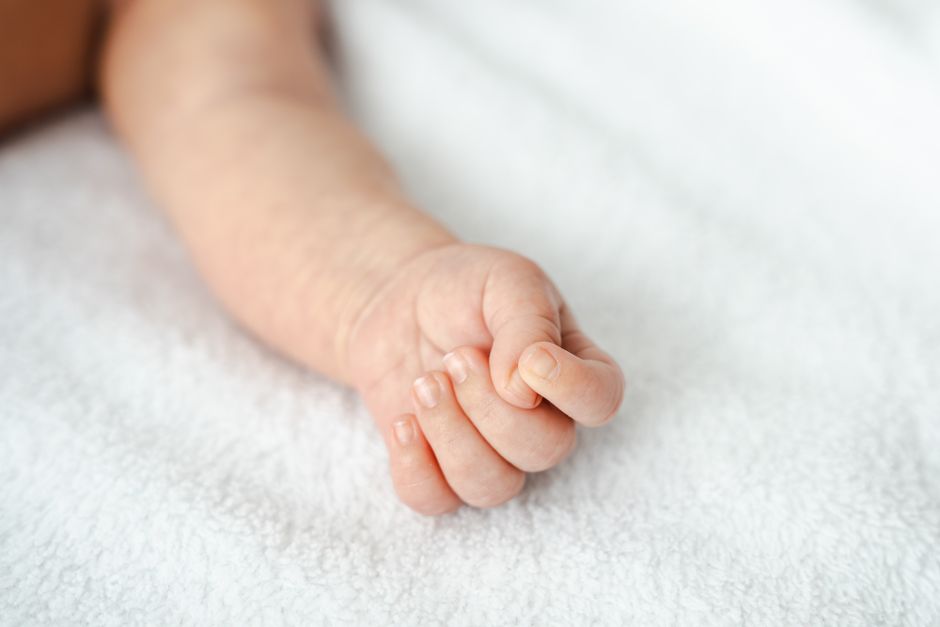 Hand eines Neugeborenen auf einer Decke (Symbolfoto)